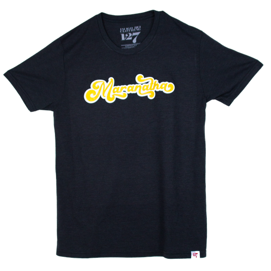 Black shirt with White under base and Gold ink saying Maranatha. Maranatha means please return Jesus.