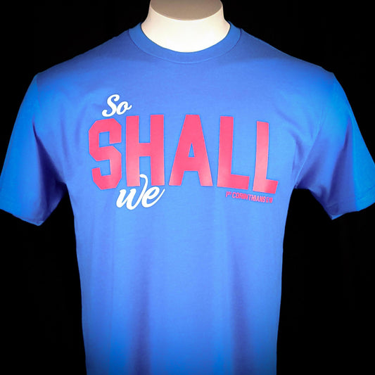 Teal blue shirt with the words So shall we across the front. The verse mentioned with 1 Corinthians
