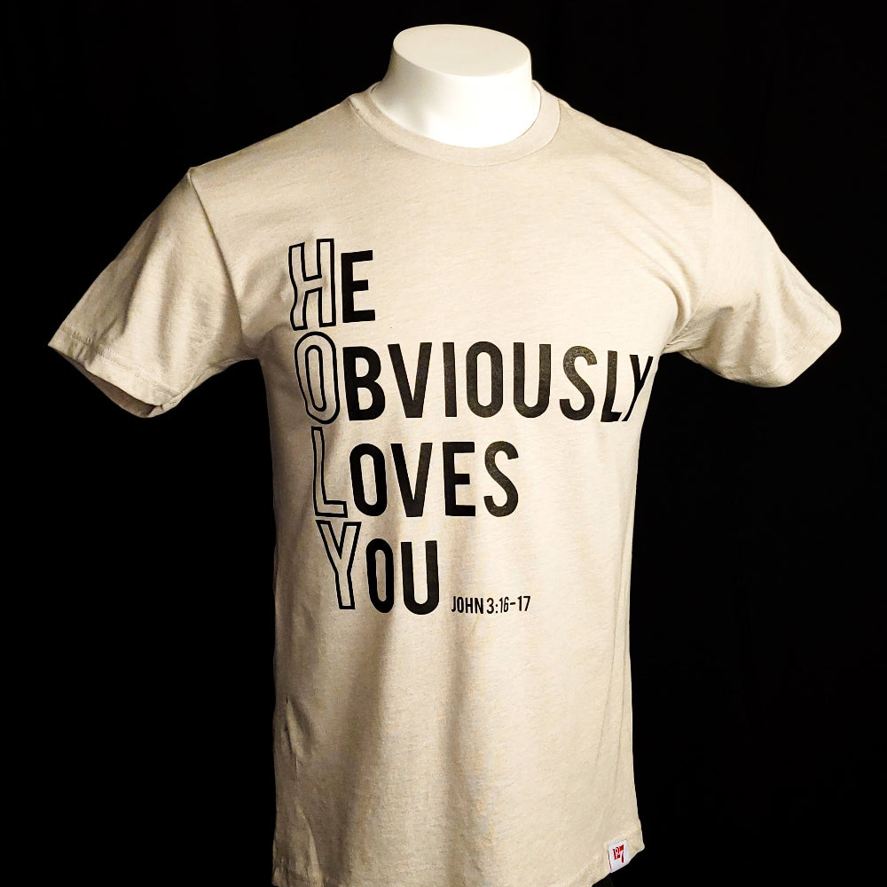 Beige t-shirt with the words He Obviously Loves You written downwards to show the word HOLY. The verse points to John 3:16-17