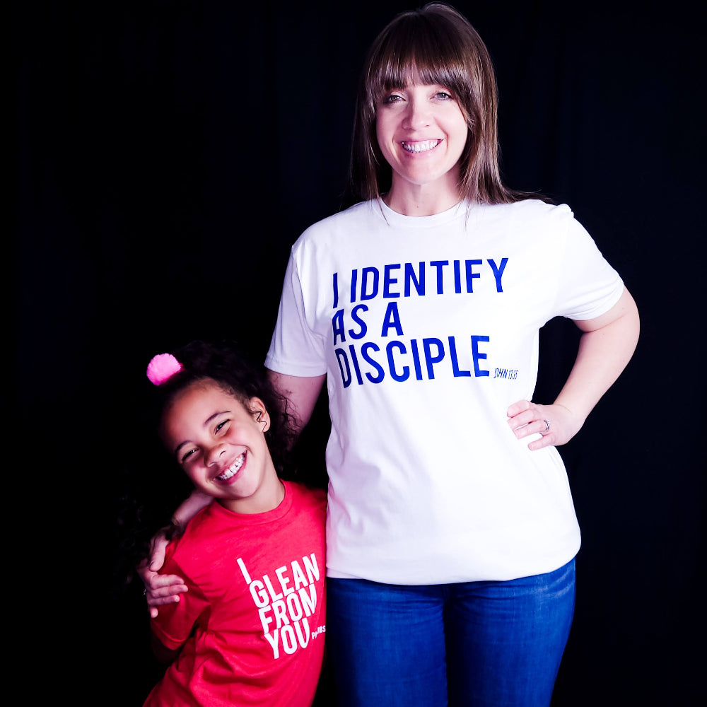 White shirt with blue writing saying I identify as a Disciple.