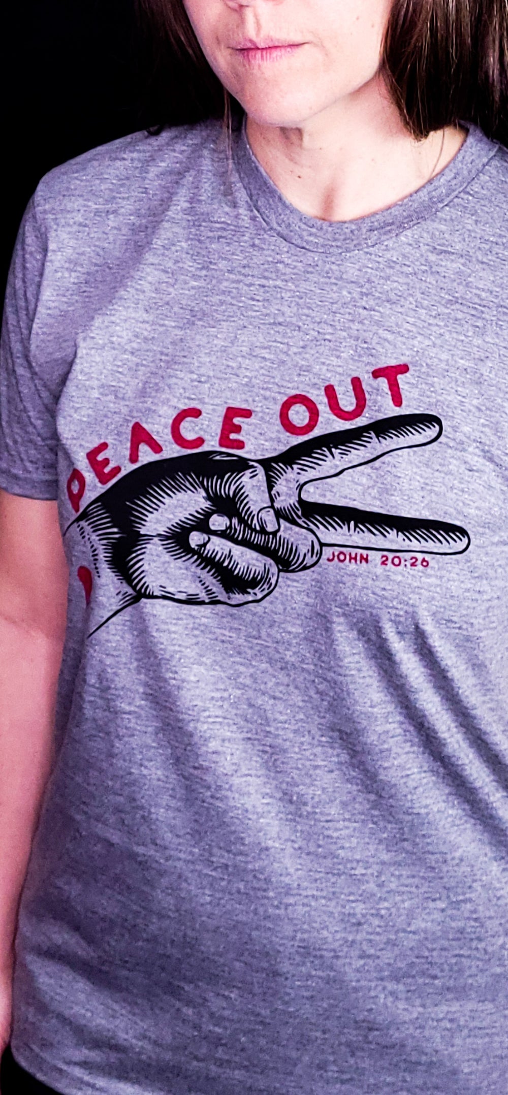 Gray shirt with the words Peace Out over two fingers making the peace sign. Referencing the verse John 20:26
