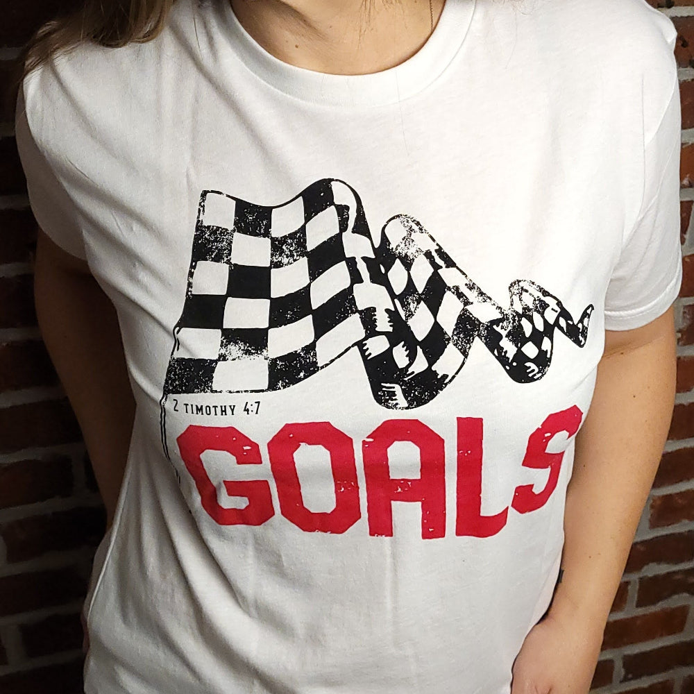 White T-shirt with the word Goals across the front underneath a checkered flag. The verse 2 Timothy 4:7