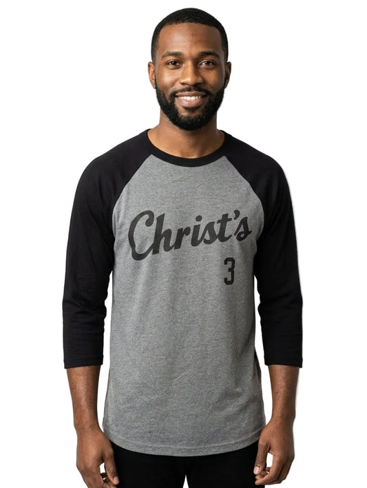 A man wearing a heather gray and black raglan baseball t-shirt with 'Christ's' and the number '3' printed on the front, photographed against a light gray studio background.