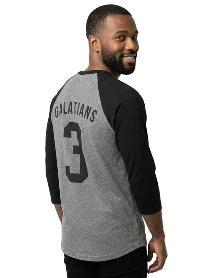 A man wearing a heather gray and black baseball t-shirt with 'GALATIANS' and the number '3' printed on the back, shown from a three-quarter back view against a light gray background.