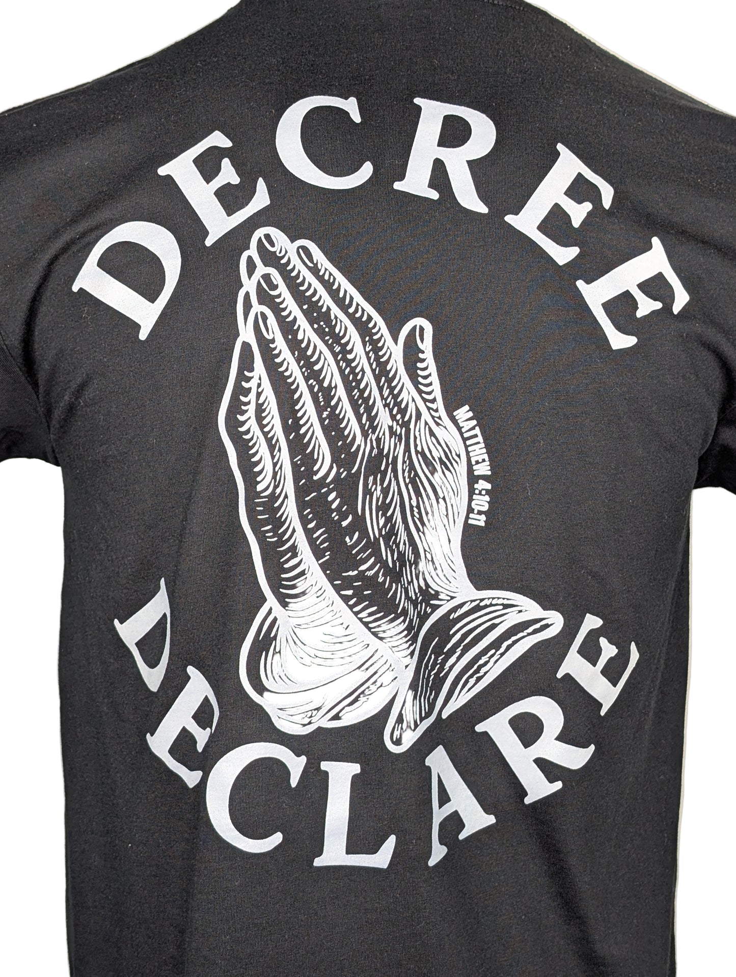 Black t-shirt with white praying hands graphic and text 'DECREE DECLARE' on a beige background