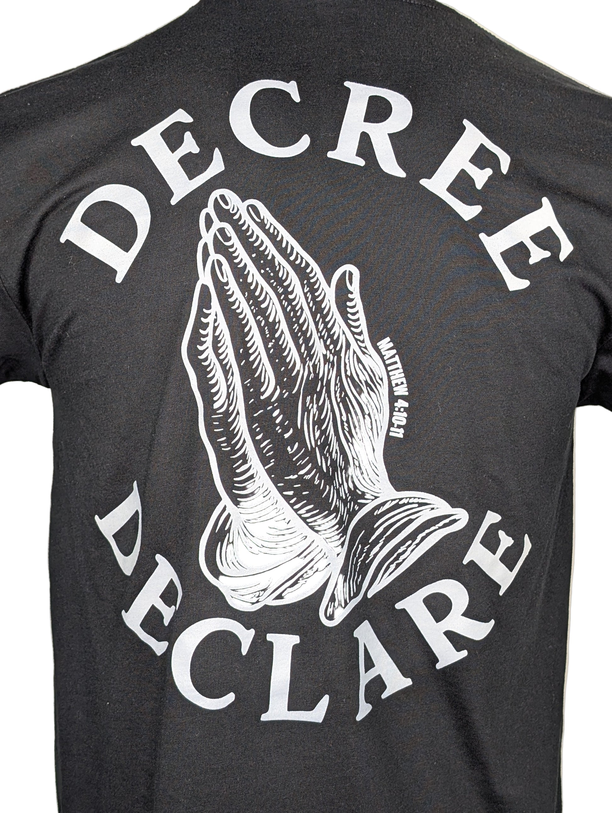 Black t-shirt with white praying hands graphic and text 'DECREE DECLARE' on a beige background