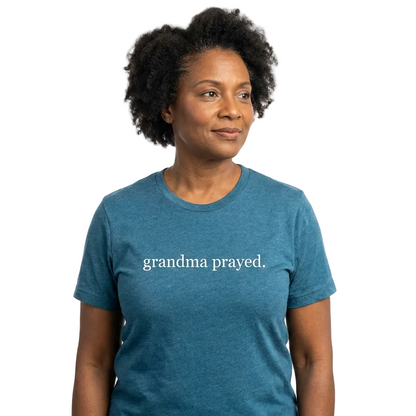 Woman wearing a blue t-shirt with 'grandma prayed' text on a white background
