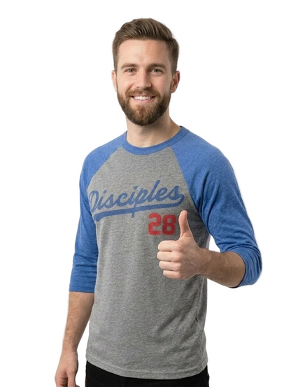 A smiling man with a beard wearing a heather gray and blue baseball-style raglan t-shirt with 'Disciples 28' printed on the front, giving a thumbs-up against a light gray background.