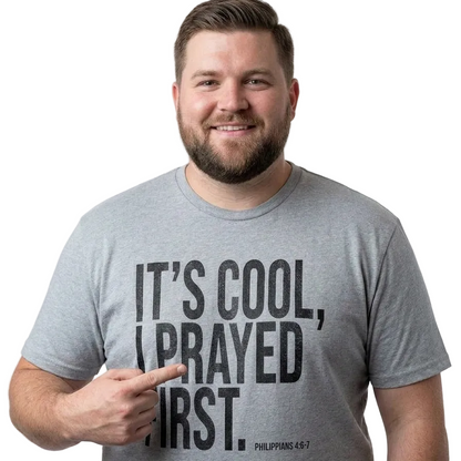 A smiling man with a beard wearing a heather gray t-shirt with the text 'IT'S COOL, I PRAYED FIRST. PHILIPPIANS 4:6-7' printed in black.