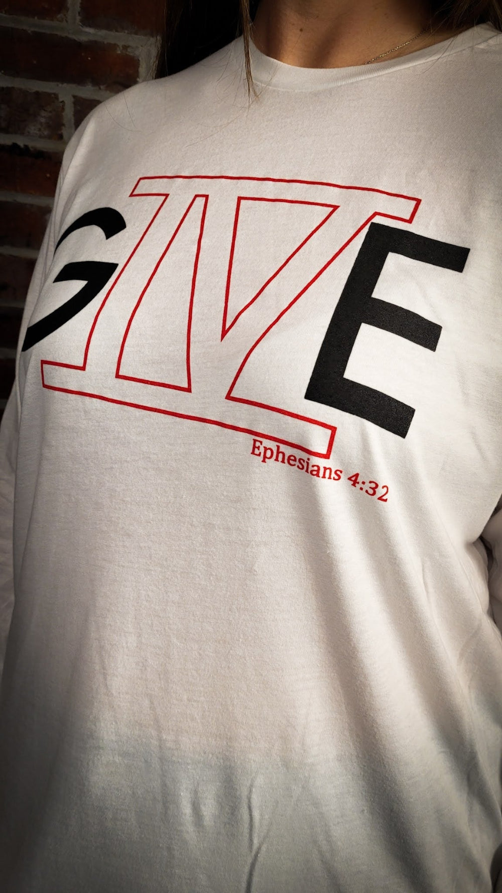 White Long sleeve shirt that says GIVE with the roman number 4 in the middle. 