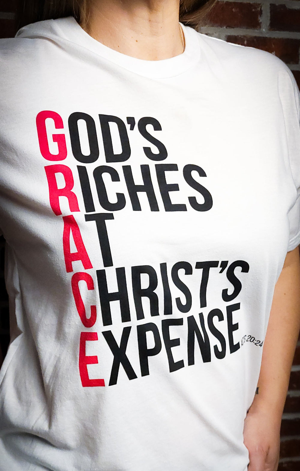 White Short sleeved t-shirt with the words God's Riches At Christ's Expense to spell out the word GRACE. Verse referenced is Acts 20:24