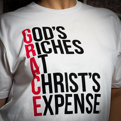 White Short sleeved t-shirt with the words God's Riches At Christ's Expense to spell out the word GRACE. Verse referenced is Acts 20:24