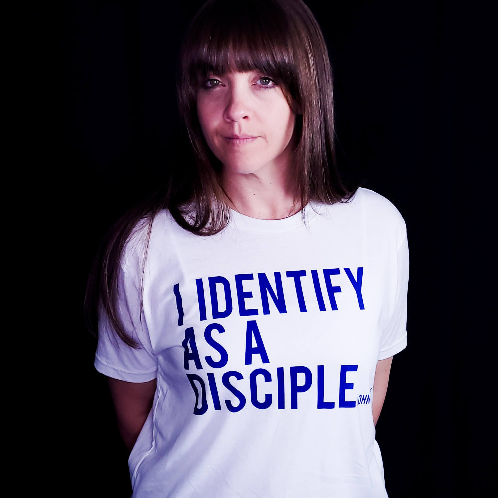 White shirt with blue writing saying I identify as a Disciple. 